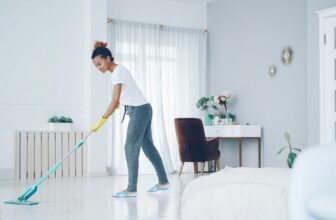 A bright and tidy living room with cleaning supplies neatly arranged, showcasing a fresh and organized atmosphere.