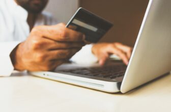A person browsing products on a laptop with shopping bags and a credit card nearby, symbolizing online shopping and smart purchasing decisions.